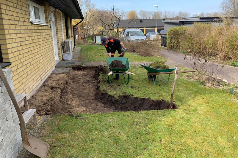 Man som arbetar på kunds trädgård